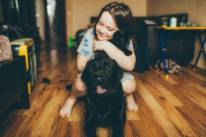 Girl Hugging Dog at Home